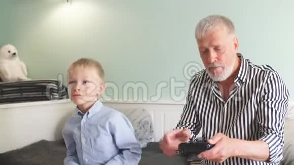 祖父和孙子用操纵杆在电脑上玩电子游戏视频的预览图