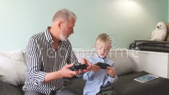 祖父和孙子用操纵杆在电脑上玩电子游戏视频的预览图