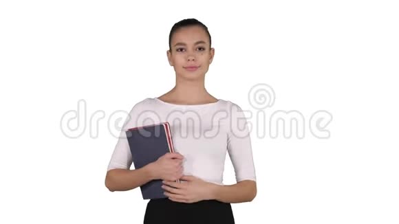 美丽的年轻女子带着笔记本走在白色的背景上视频的预览图