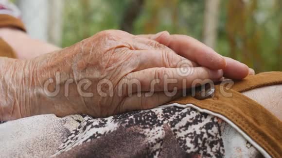 年轻的男性手臂安慰一双年长的老妇人的手在户外孙子和奶奶在一起视频的预览图