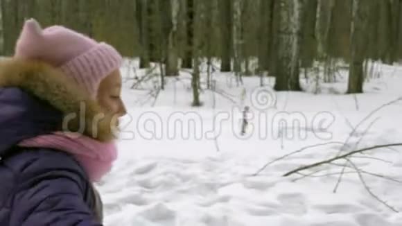 女孩在冬天的森林里跑步在家庭散步森林中的寒假视频的预览图