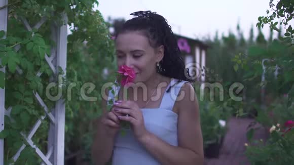 成年女士闻到花园里的花香视频的预览图