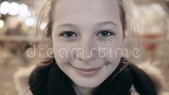 特写肖像一个快乐的年轻微笑女孩看着相机街上美丽的女孩她身上的光视频的预览图