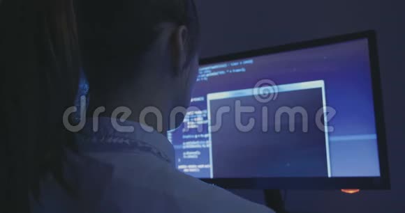 年轻女性黑客程序员晚上在数据中心的电脑上工作的肖像后景视频的预览图