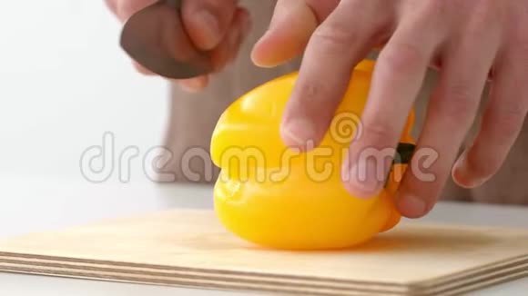 厨师用手缓慢地在木板上切出新鲜的黄钟椒视频的预览图