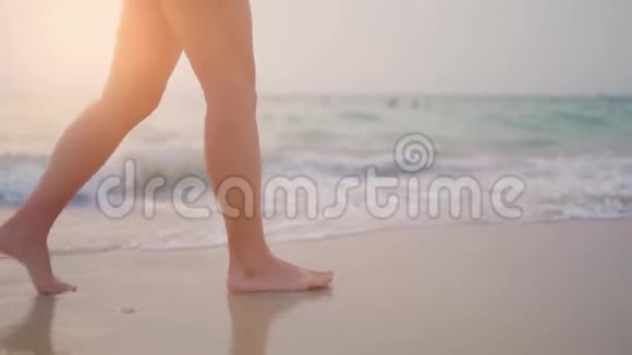 年轻女子长腿在浅海的异国沙滩上散步向四周喷水视频的预览图