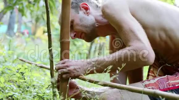 一个白种人用竹木在花园里筑天然栅栏视频的预览图