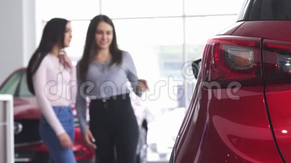 两个女人在经销商展厅讨论一辆新车视频的预览图