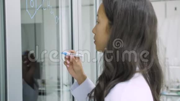 医学研究科学家在玻璃白板上写下科学公式视频的预览图
