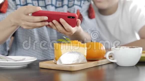 时髦的家庭母子在一家餐馆用手机相机制作食物照片视频的预览图