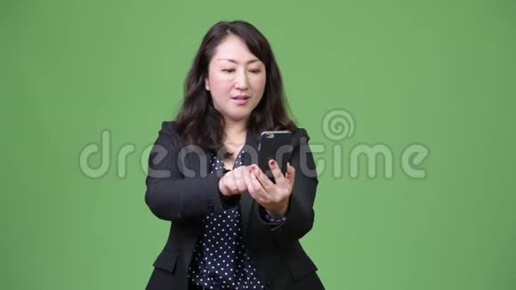 成熟美丽的亚洲女商人使用电话得到好消息视频的预览图