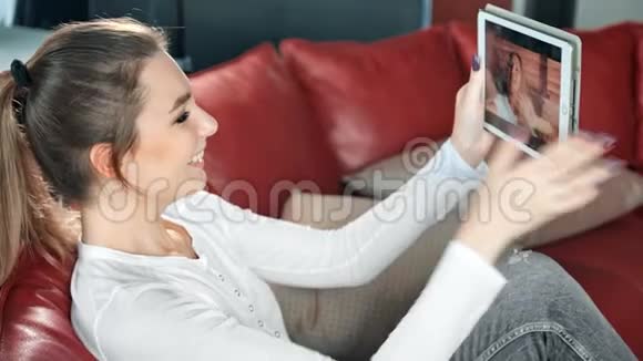 年轻快乐的女人和她的朋友在数码平板电脑上玩电子游戏视频的预览图