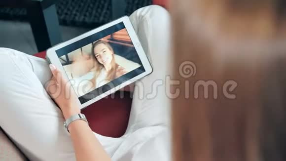年轻快乐的女人和她的朋友在数码平板电脑上玩电子游戏视频的预览图