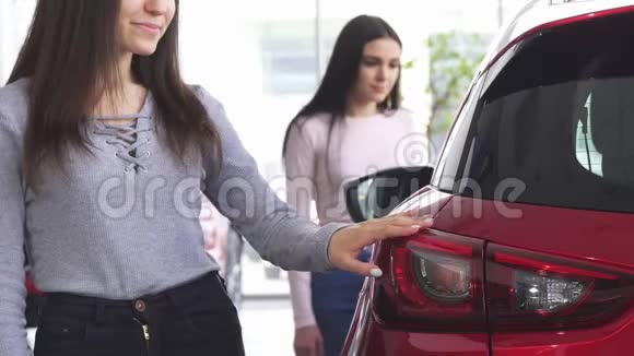 两个女人在经销店选择汽车的镜头视频的预览图