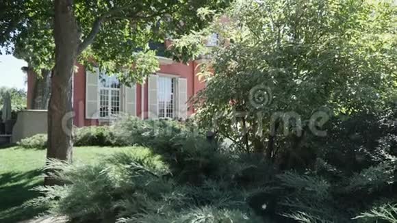 一座漂亮的房子附近的树和灌木视频的预览图