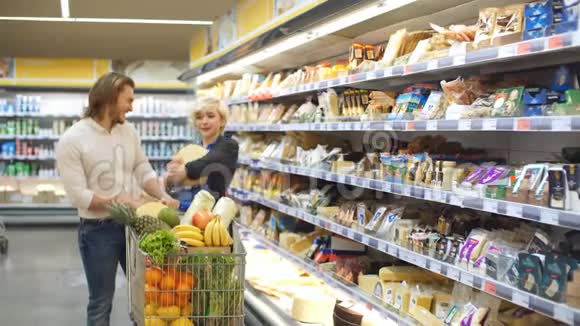 男性和女性购物者用超市过道上的食品推车视频的预览图
