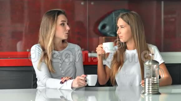 两个女朋友在厨房里喝咖啡聊天玩得开心视频的预览图