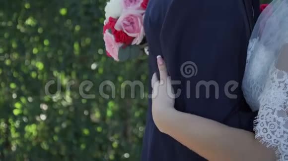 新娘双手捧着花束搂住新郎的腰视频的预览图
