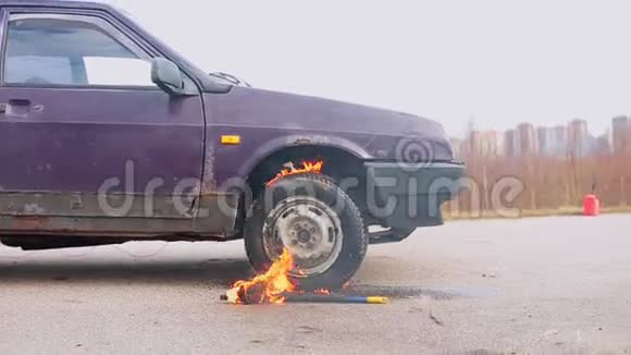 旧的紫罗兰车在空灰尘路上在寒冷的日子里用燃烧的车轮视频的预览图