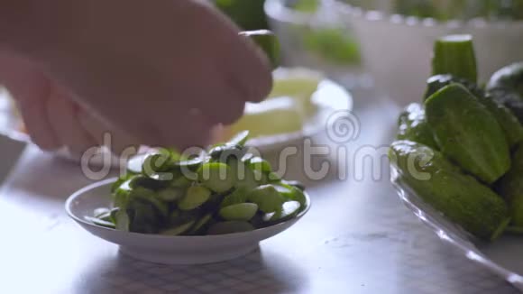 厨房餐桌上的女切黄瓜的特写视频的预览图