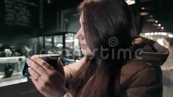 一位美丽的黑发女郎在一家夜店喝咖啡梳头视频的预览图