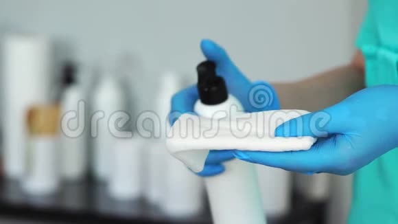 在美容院的餐巾纸上用戴手套的手贴上护肤品视频的预览图