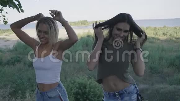 两个活泼有趣的女孩正在户外跳舞和开玩笑视频的预览图