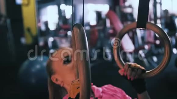 在交叉健身馆用体操戒指锻炼的女孩视频的预览图
