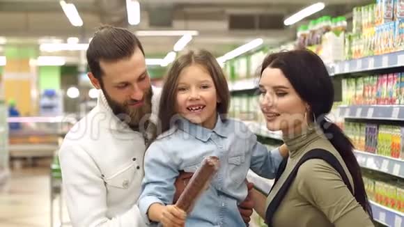 年轻幸福的家庭在超市买香肠慢动作视频的预览图