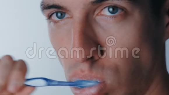 他用白色背景刷牙时的嘴角特写视频的预览图