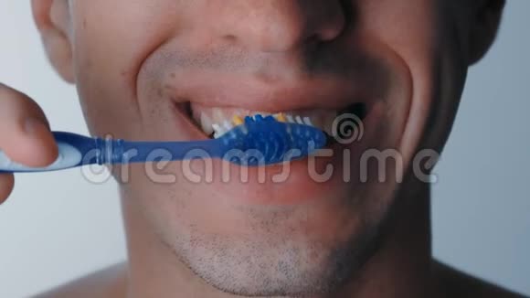 他用白色背景刷牙时的嘴角特写视频的预览图