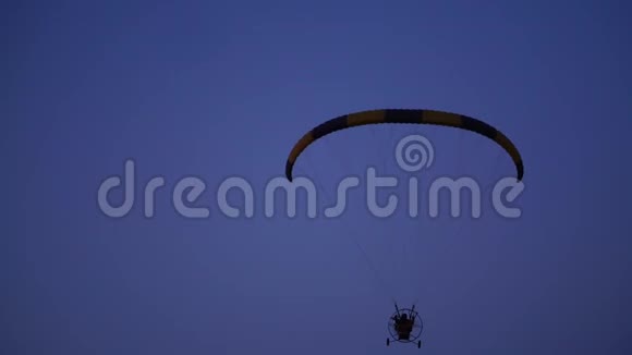滑翔伞上的飞行员从照相机里飞过渐渐地飞向远处飞向蓝天视频的预览图