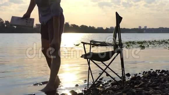 在斯隆莫的河岸上年轻人站在折叠椅上坐下视频的预览图