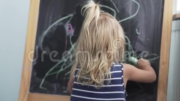 小女孩在黑板上画粉笔视频的预览图