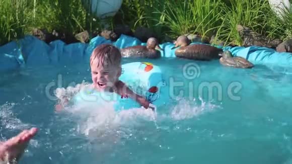 这个男孩正在一个小池塘里游泳这个孩子在炎热的夏日里享受清凉的水快乐的童年花和草视频的预览图