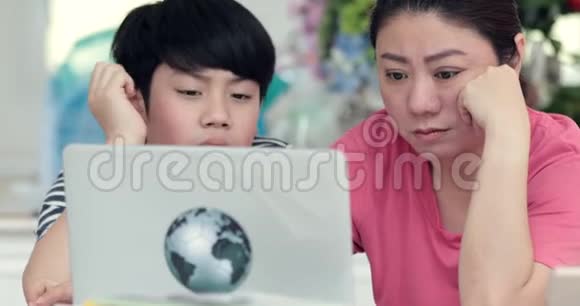 亚洲母子对笔记本电脑的学习和阅读教育感到厌烦视频的预览图
