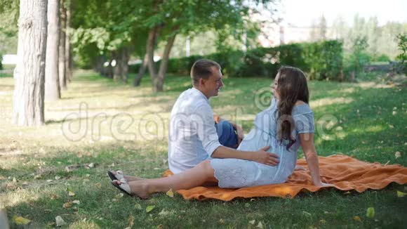 幸福的怀孕夫妇在城市公园聊天视频的预览图