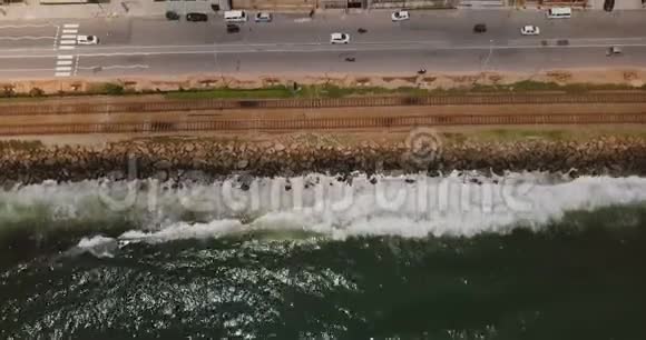 在斯里兰卡科伦坡海岸线上空飞行的无人机海景铁路街道交通和建筑物视频的预览图