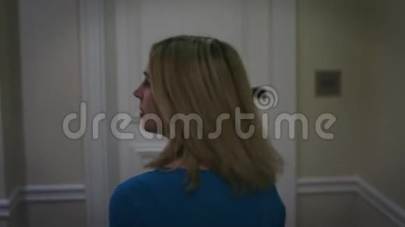 穿着蓝色连衣裙的漂亮女人在走廊公寓酒店的搜房视频的预览图