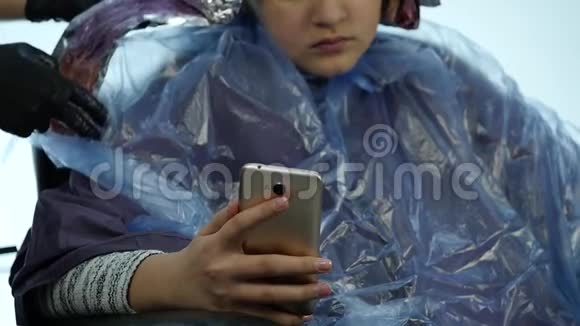 女孩在电话里说话理发师在美容院为一个十几岁的孩子做发型慢动作视频的预览图