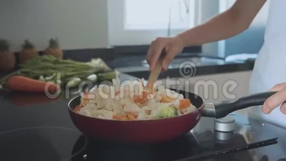 女人在煎锅上拌菜特写视频的预览图