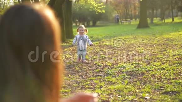 美丽的女儿在春天的公园里跑向妈妈拥抱她有趣的小女孩在享受阳光视频的预览图