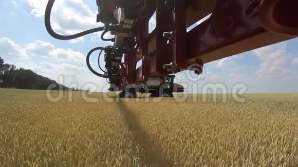 从自动推进喷雾机的手臂上看到喷洒水在小麦上视频的预览图