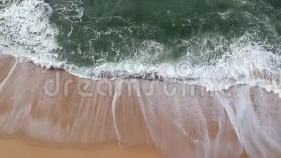 夏天美丽的空中无人机在葡萄牙金色沙滩上拍击海浪视频的预览图