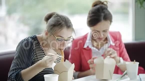 两个女人在办公室里集思广益吃面筷子视频的预览图