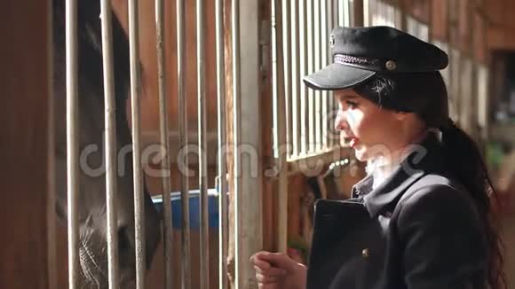 女孩模特在马场的马厩里摆姿势慢动作视频的预览图