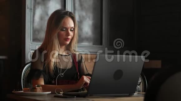 快乐的年轻女子在咖啡馆里喝咖啡使用平板电脑视频的预览图
