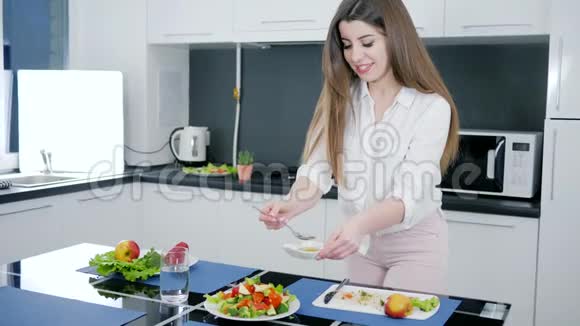 女孩在新鲜沙拉上倒入橄榄油在厨房慢动作的蔬菜视频的预览图