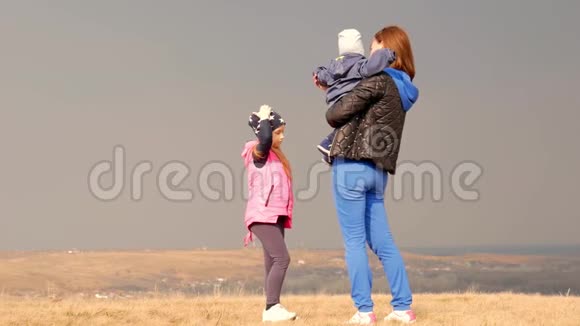 年轻的母亲和她的孩子在美丽的春天户外妈妈和两个孩子在公园里玩家庭娱乐视频的预览图