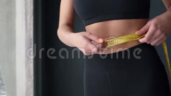 用卷尺量腰的健身妇女视频的预览图